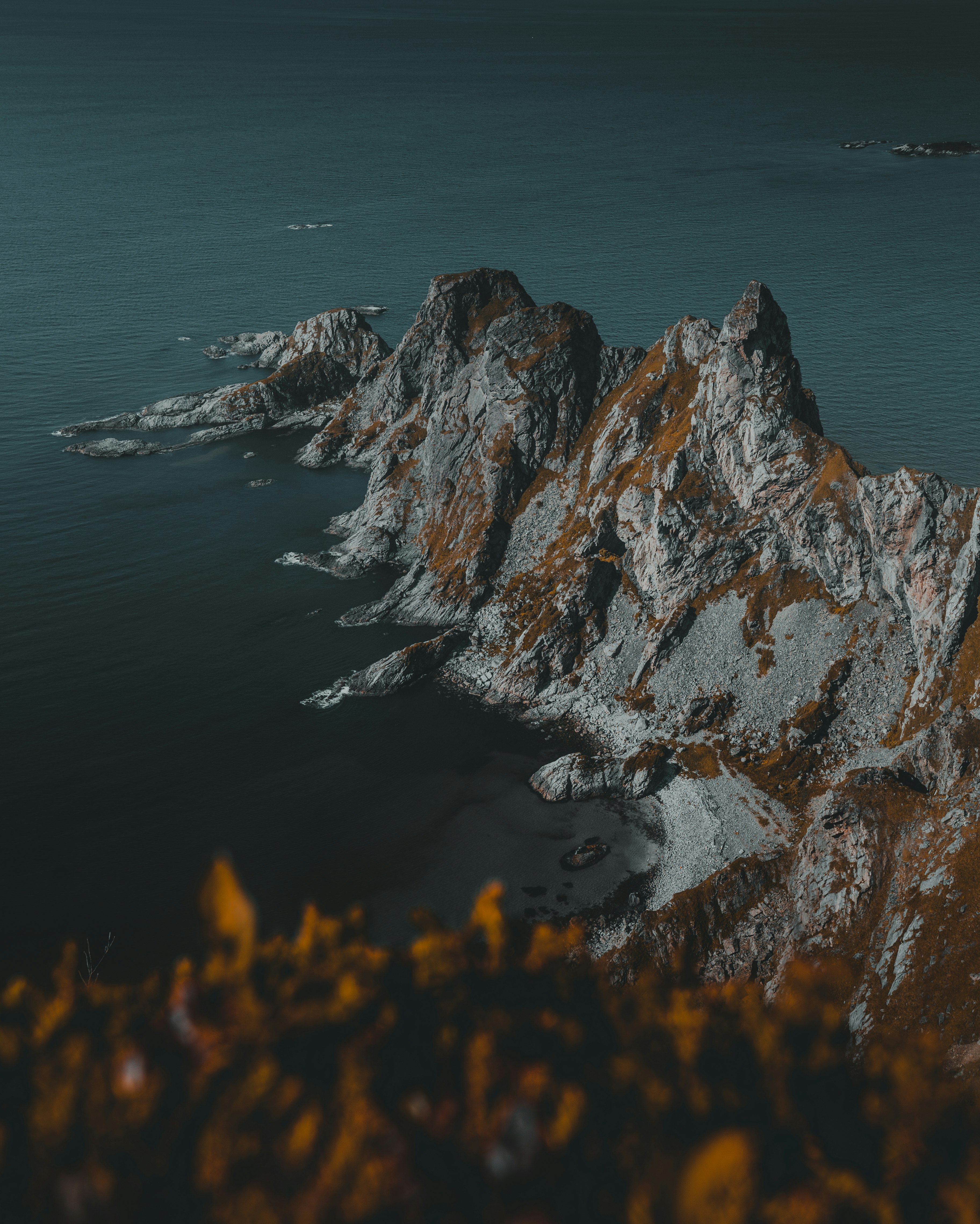 brown and gray rock formation beside body of water during daytime